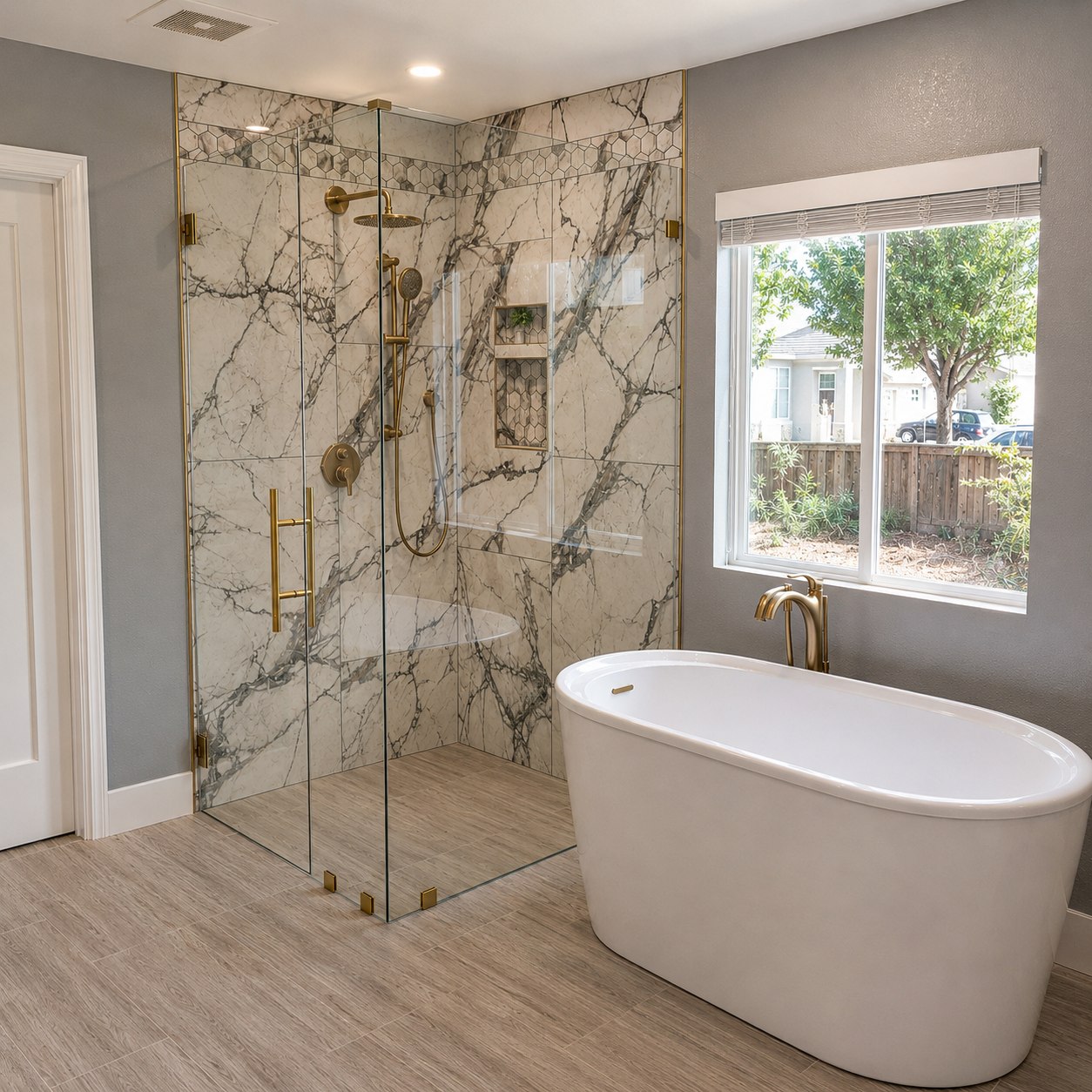 Completed Brown Dog Builders bathroom with a glass shower enclosure, brass fixtures, and a freestanding tub